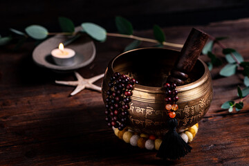 Close-up of a singing bowl and prayer beads (mala) for chanting mantras as a decoration on an old...