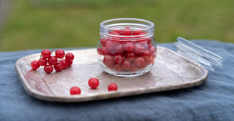 Red berries in a jar on a copper tray. Horizontal orientation.