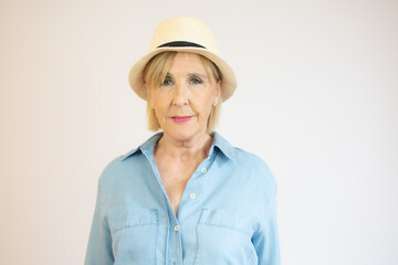 Image of senior woman with short blond hair wearing straw summer hat