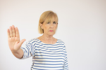 gesture, prohibition and old people concept - portrait of senior woman showing stop sign over white background