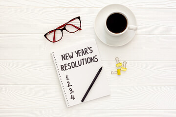 New Year's resolutions with Christmas decorations on yellow flat lay