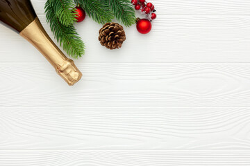 Fototapeta na wymiar New Year decoration with champagne bottle and fir branches on white wooden background top view