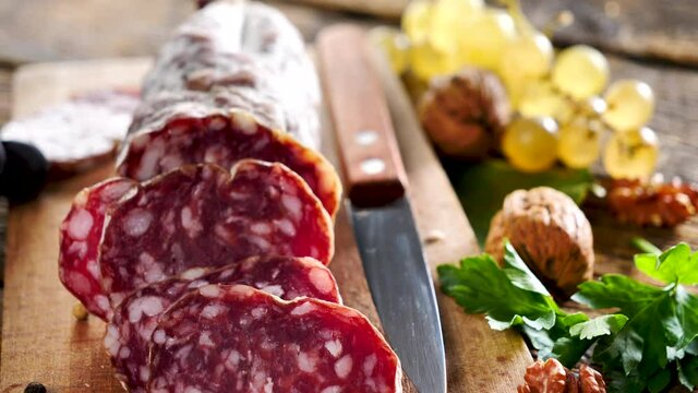 salami with grape and walnut on wooden board