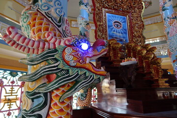 Hoi An, Vietnam, November 19, 2020: Dragon next to The All-Seeing Eye in the main hall of worship of the Cao Dai temple in Hoi An