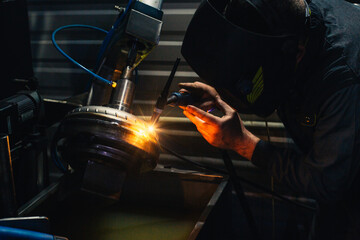 welding torque converter parts in a workshop sparks