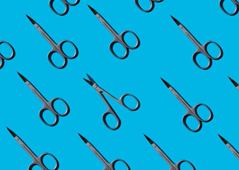 metal manicure small scissors on a blue background. Health and beauty, personal care. flat lay, top view.