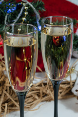 Close-up. Two glasses of champagne. Windrik Christmas background with drinks. Against the background of an orange.