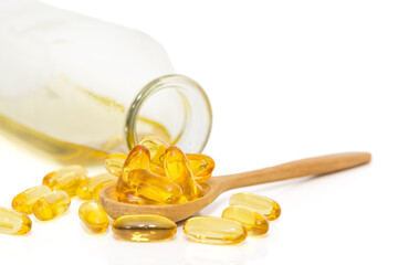 Bottle of fish oil and omega 3 in a wooden spoon