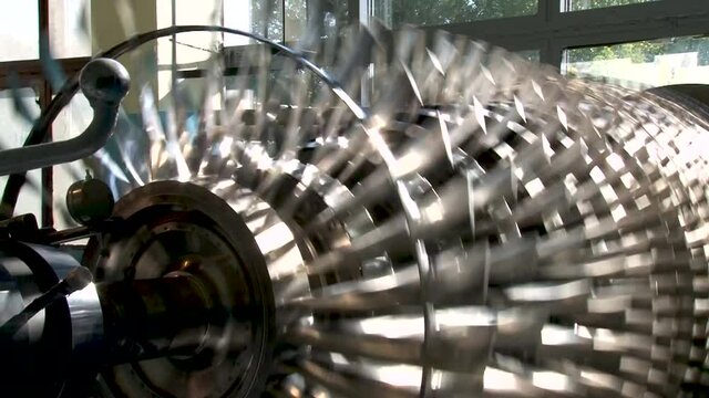 Compressor rotor balancing at stand. Repair of gas turbine engines. Compressor rotor is mounted on stand and rotates. Blades rotor compressor close-up.
