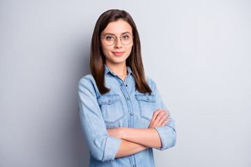 Portrait of nice intellectual brunette hairdo office worker crossed arms wear spectacles blue cloth...