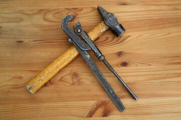 Hammer and adjustable wrench on a wooden table