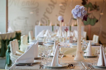 Beautiful table decoration detail inside a restaurant prepared for the wedding reception guests.
