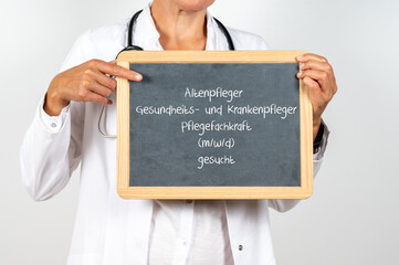 Ärztin mit einem Schild auf dem Altenpfleger Gesundheits und Krankenpfleger oder Pflegekraft...