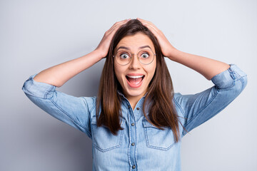 Photo of attractive surprised girl hold hands head unbelievable wear glasses isolated on grey color...