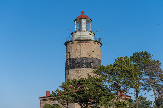 A brick lighthouse with a bright blue sky in the background. Picture of Falsterbo Lighthouse built in 1796, Scania, Sweden