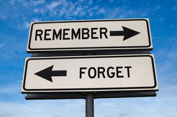 Remember versus forget road sign. White two street signs with arrow on metal pole with word. Directional road. Crossroads Road Sign, Two Arrow. Blue sky background. Two way road sign with text. - obrazy, fototapety, plakaty