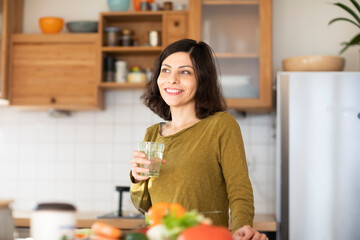 Obraz na płótnie Canvas Frau mit langen schwarzen Haaren arbeitet in der Küche 