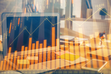 Double exposure of chart and financial info and work space with computer background. Concept of international online trading.