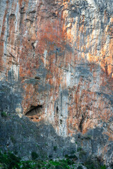 Two athletes practicing climbing on a vertical wall and high above the ground.