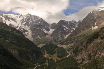Bellissima parete Est del Monte Rosa ripresa da Macugnaga, Italia, con nuvole bianche, cielo azzurro e colori tenui