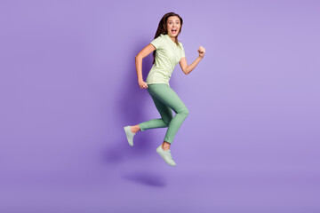 Fototapeta na wymiar Full body profile photo of impressed ecstatic person open mouth shout run jump wear green isolated on violet color background