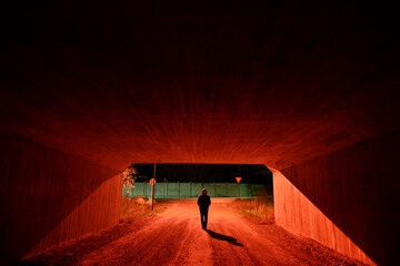 Stockholm, Sweden A man walks through a red-lit pedestrian tunnel