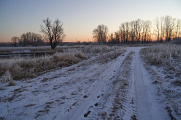 Breath of winter, first ice on the lake, dawn on a frosty morning with frost on the grass, close-up of frost, patterns on the first ice.