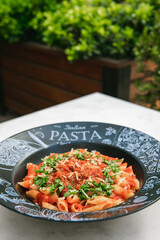 Penne pasta bolognese in tomato sauce with vegetables.