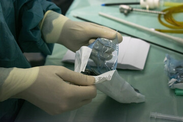 Selective focus shot of a doctor opening a sterilized package of the medical instruments