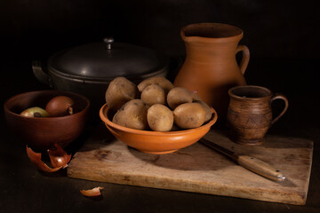 Still life with old ceramic and raw potato dishes