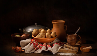 Still life with old ceramic and raw potato dishes
