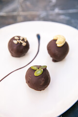 Chocolate balls, cocoa balls, chocolate truffles or pralines in plate.