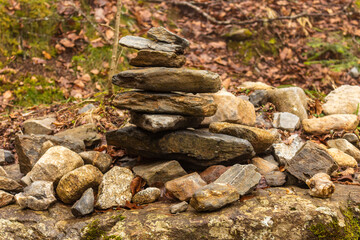 Fototapeta na wymiar Balanced cairn or troll stoned pyramid, tourist memory sign or hiking path marking at the Valley Val d’Astau, southwest of Bagneres de Luchon in the French Pyrenees. The trail to Lake d'Oô, France.