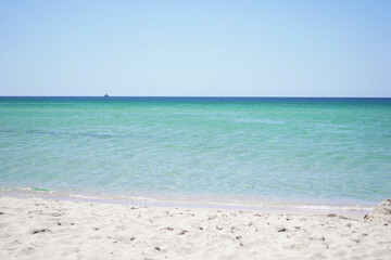 Fototapeta na wymiar Beautiful sea view of the azure sea on a Sunny summer day on a sandy beach.