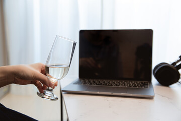 パソコンの前で飲み物を飲む。家でリモート・オンライン飲み、おうち時間。