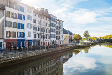 views of nive river in bayonne with traditional houses at background