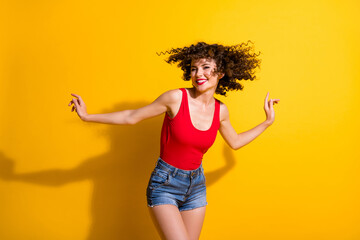 Fototapeta na wymiar Portrait of her she nice attractive lovely slim thin slender cheerful cheery carefree wavy-haired girl dancing having fun free spare time isolated bright vivid shine vibrant yellow color background