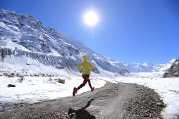 Woman trail runner  cross country running  in winter mountains