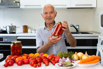 old gray haired man makes harvests for the winter pickles tomatoes