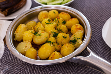 Naklejka na ściany i meble toasted young potatoes with dill in metal skillet