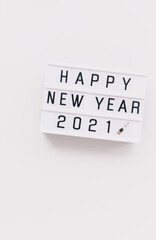 Light board with text Happy New Year 2021 on white background. Copy space, minimal. 