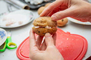 The girl gently presses the bacon with potatoes on both sides.