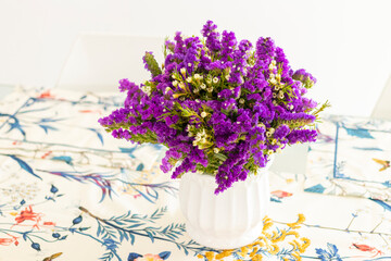 Cute flower arrangement with purple statice, decorating the dinner table