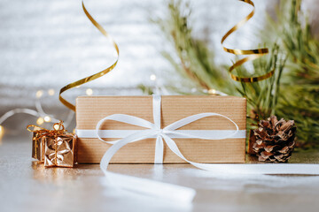 Christmas gifts in lights with pine cones and fir branches in a festive new year atmosphere on a...