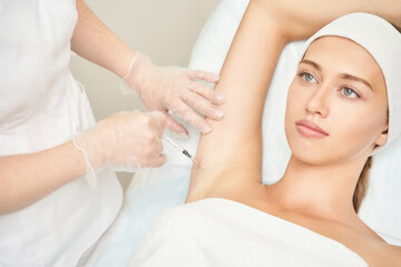 Armpit injection at spa salon. Doctor hands. Closeup view. High quality. Pretty female patient....