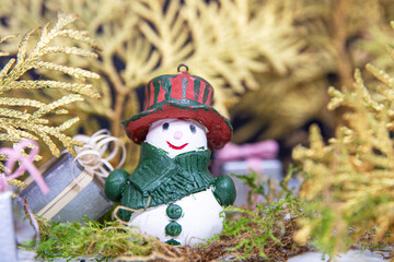 snowman with gifts on a background of golden Christmas trees