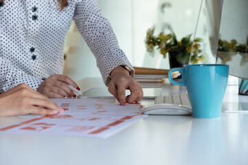 Cropped shot of two UI developers meeting on their project with paperwork and tablet on meeting...