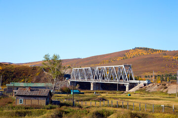 Railway bridge on the background of autumn nature. Horizontally.