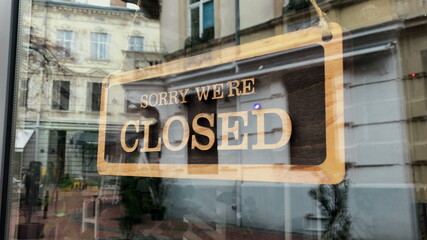 Temporarily closed sign for Covid-19 in small business activity. Close up on closed placard in the...