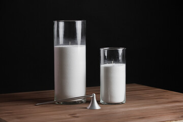 Glass candlestick with a candle isolated on a black background.